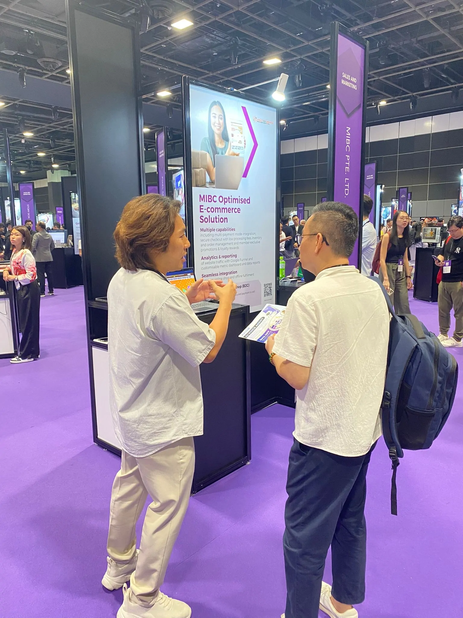 MIBC team member speaking with a visitor at the SMEs Go Digital Day 2025 booth